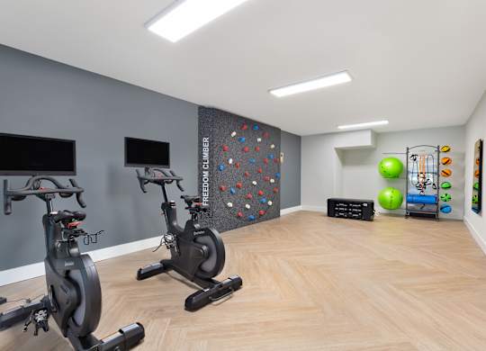 a gym with exercise machines and a rock climbing wall at Copper and Quarry Village, Maryland, 21209