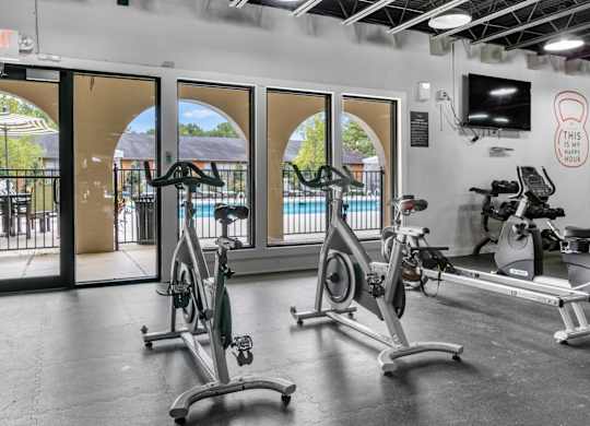 A gym with exercise bikes and a television. at Riverchase Landing Apartments, Hoover