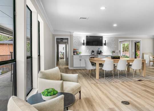 A modern living room with a dining area and kitchen in the background. at Riverchase Landing Apartments, Hoover