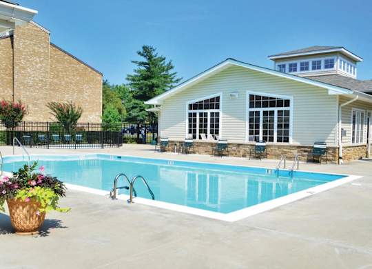 Swimming pool with clubhouse and sun loungers at The at Elmwood Terrace Apartments, Frederick, MD