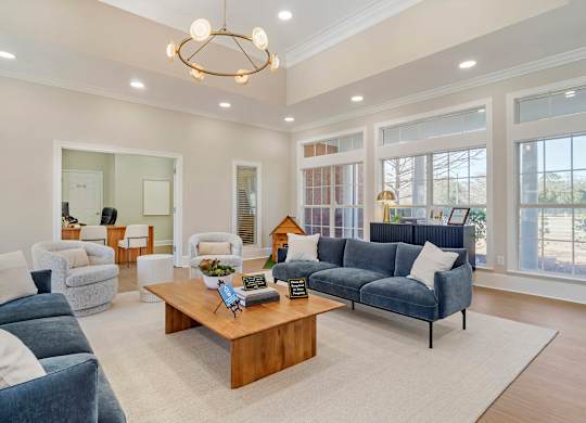 A living room with a blue couch and a wooden coffee table. at Greenbrier Estates, Slidell, 70460
