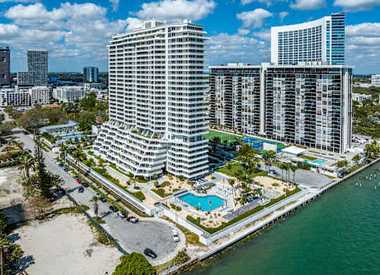 A large white building with a pool in front of it. at The Hamilton, Miami, FL