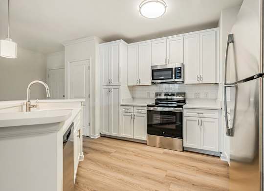 A kitchen with white cabinets and stainless steel appliances.at River House Apartments, Virginia, 23504