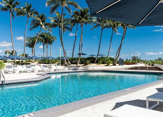 a swimming pool at a resort with palm trees at The Hamilton, Miami, Florida