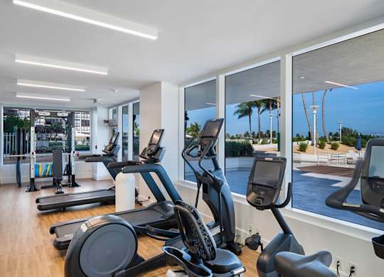a gym with a view of the pool and the beach at The Hamilton, Miami, 33137