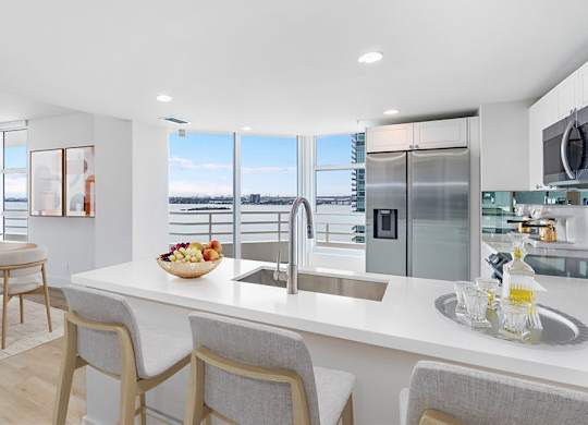 an open kitchen and dining area with a view of the ocean at The Hamilton, Miami