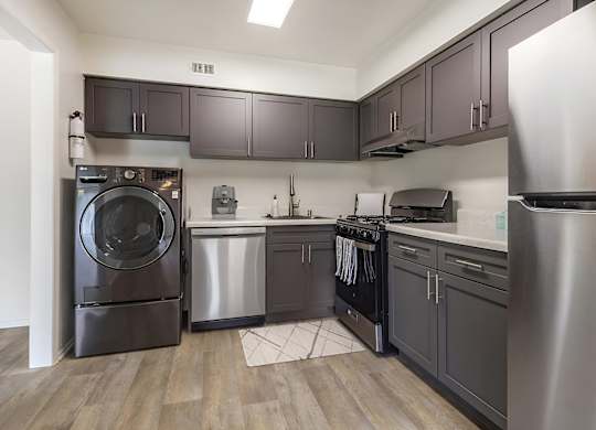 a kitchen with gray cabinets and stainless steel appliances at Copper and Quarry Village, Maryland, 21209