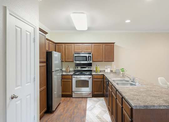 Kitchen with wooden cabinets and appliances at Reflections of Island Park Apartments, Shreveport, LA