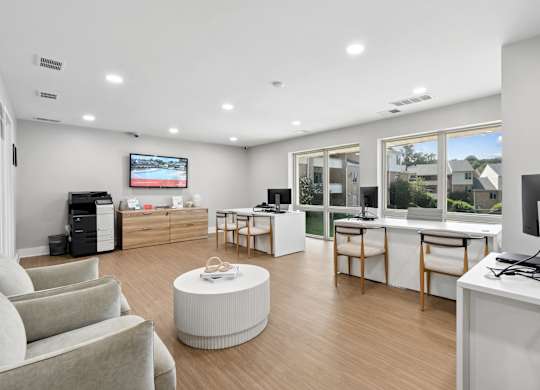 A modern office space with a flat-screen TV mounted on the wall.