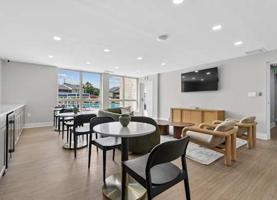 A modern dining area with a table set for six and a television mounted on the wall.
