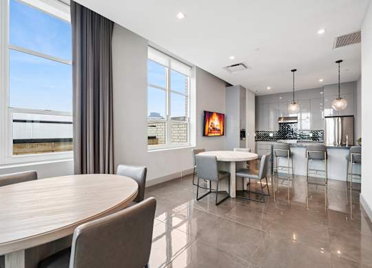 A modern dining room with a large table and chairs.
