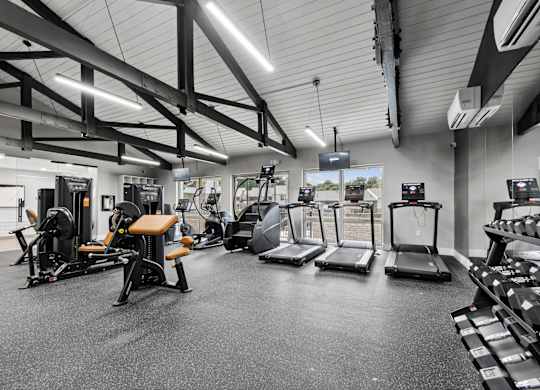 A gym with treadmills, weights, and exercise equipment.