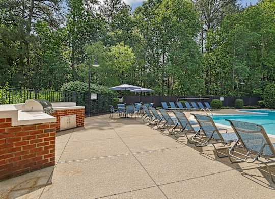 A poolside area with sun loungers and a brick wall.