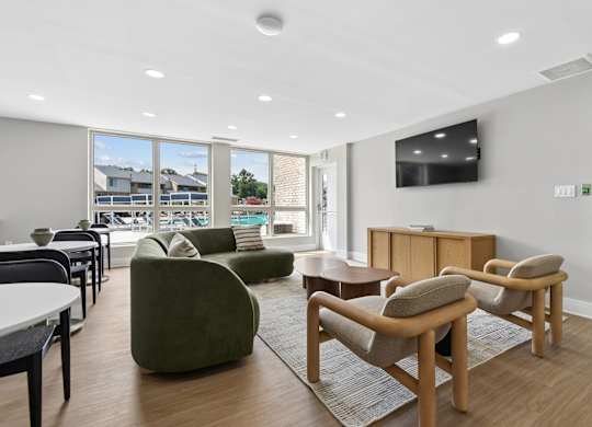 A living room with a green chair and a television on the wall.