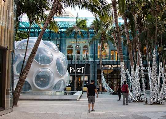 people walking in front of a building with palm trees at The Hamilton, Miami, 33137