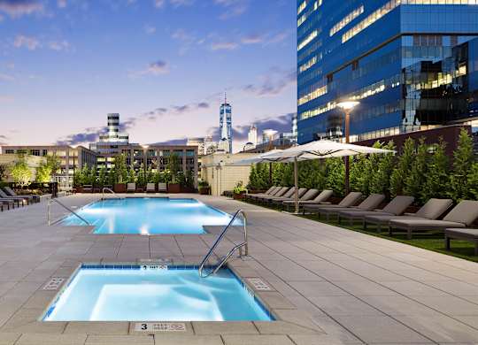 A large swimming pool surrounded by lounge chairs and umbrellas.