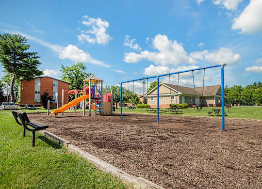 A Playground with Swings at The Manor/The Manor East Apartments, Leesburg, VA