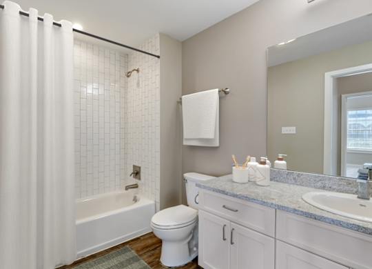 a bathroom with a shower and a toilet and a sink at Villaggio Apartments, Bossier City