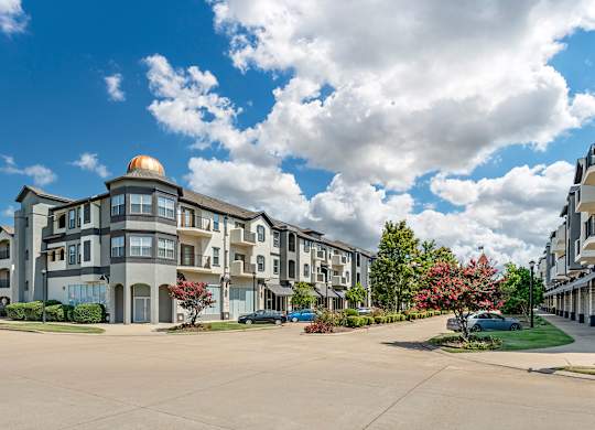 a large apartment building on the corner of a street at Villaggio Apartments, Bossier City