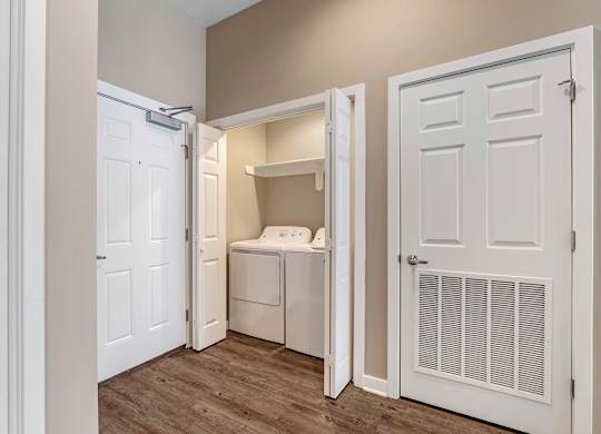 a laundry room with a washer and dryer and a closet with a door at Villaggio Apartments, Louisiana