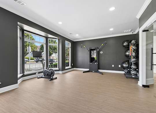 A spacious room with a treadmill, exercise bike, and weights.