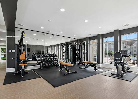 A gym with a variety of equipment including weights and cardio machines.