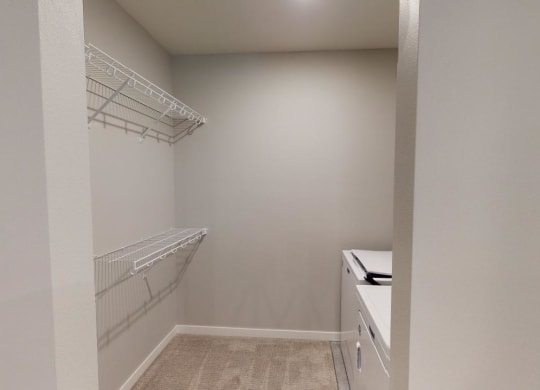 a walk in closet in a home with white walls and shelvesat Northern Lights a Lifestyle-Driven Community, West Fargo, 58078