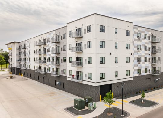 a large white apartment building with a street in front of itat Northern Lights a Lifestyle-Driven Community, West Fargo, North Dakota