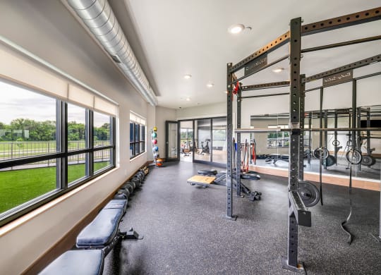 a gym with windows and weights machines and a view of the grassat Northern Lights a Lifestyle-Driven Community, West Fargo, ND, 58078