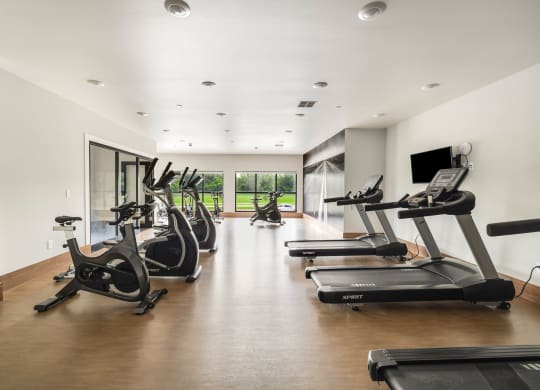 a gym with treadmills and a tv on the wallat Northern Lights a Lifestyle-Driven Community, West Fargo, North Dakota