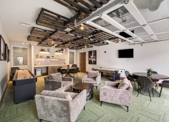 a lounge area with couches chairs and tables and a projection screen on the ceilingat Northern Lights a Lifestyle-Driven Community, West Fargo, North Dakota
