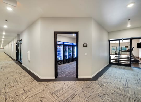 a long corridor with doors and vending machines in a buildingat Northern Lights a Lifestyle-Driven Community, West Fargo, 58078