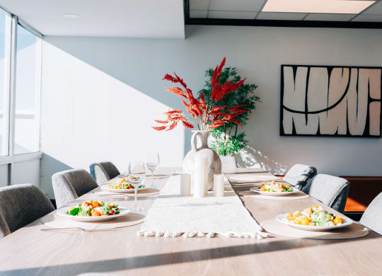 a long dining table with plates of food and a vase of flowers at Vision on Lombard, Baltimore, MD 21201