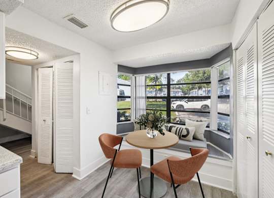 A dining area with a round table and chairs.