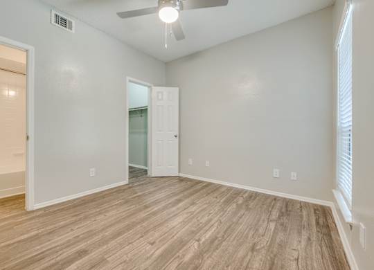 an empty living room with wood flooring and a ceiling fan at Foxborough Apartments, Irving, TX, Texas, 75061