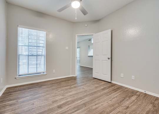 an empty living room with a white door and a ceiling fan at Foxborough Apartments, Irving, TX, Texas, 75061