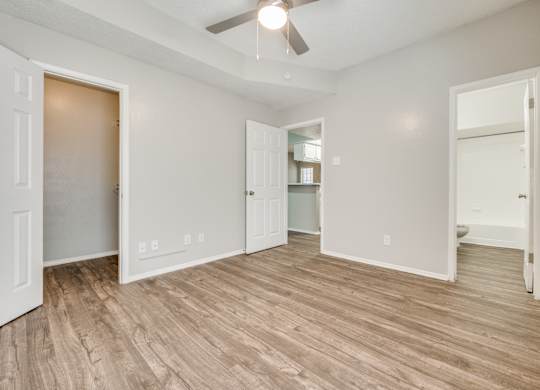 an empty living room with a wood floor and a ceiling fan at Foxborough Apartments, Irving, TX, Texas, 75061