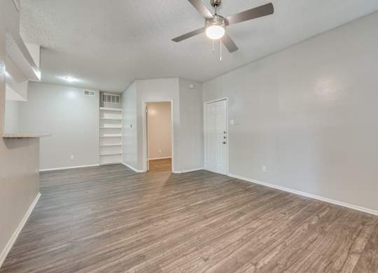 an empty living room with wood flooring and a ceiling fan at Foxborough Apartments, Irving, TX, Texas, 75061