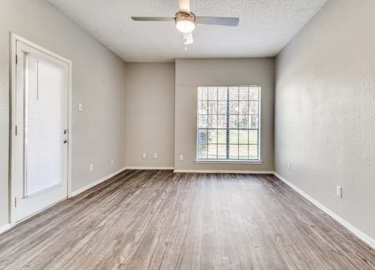 an empty living room with a ceiling fan at Foxborough Apartments, Irving, TX, Texas