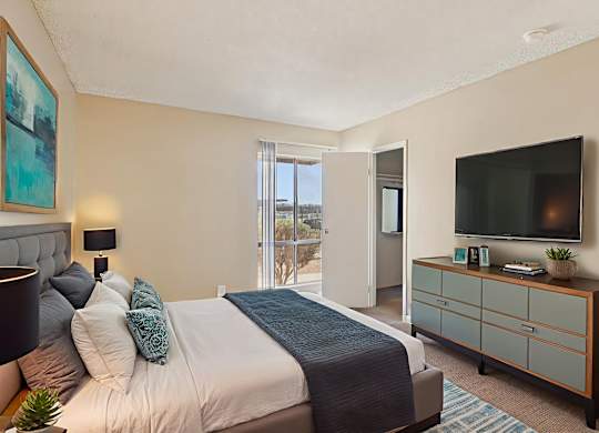A bedroom with a bed, nightstand, and a television.