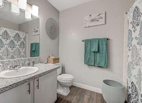 a bathroom with a toilet sink and mirror and a shower at Desert Bay Apartments, Laughlin