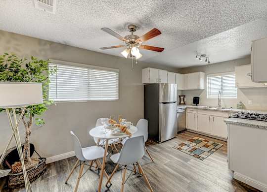 an open kitchen and dining room with a white table and chairs at Desert Bay Apartments, Laughlin, NV, 89029