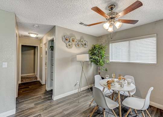 a dining room with a table and chairs and a ceiling fan at Desert Bay Apartments, Laughlin, NV