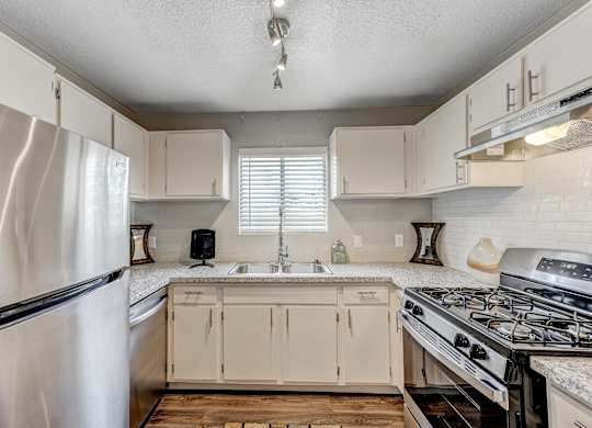 an updated kitchen with white cabinets and stainless steel appliances at Desert Bay Apartments, Laughlin, NV, 89029