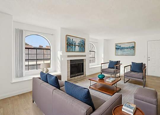 A living room with a fireplace and a painting on the wall.