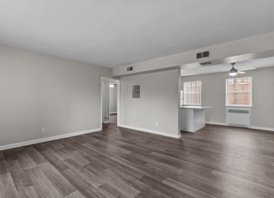 the living room and dining room of an empty house with wood flooring