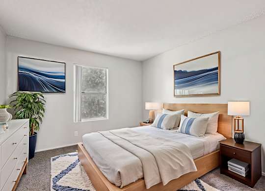 A bedroom with a large bed and a painting on the wall.