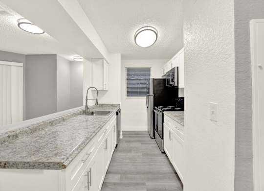 A kitchen with granite countertops and white cabinets. at Village Park, Orlando, FL
