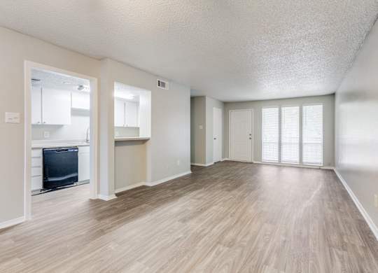 an empty living room and kitchen with a hard wood floor at Falls on Clearwood Apartments, Richardson, TX, Texas
