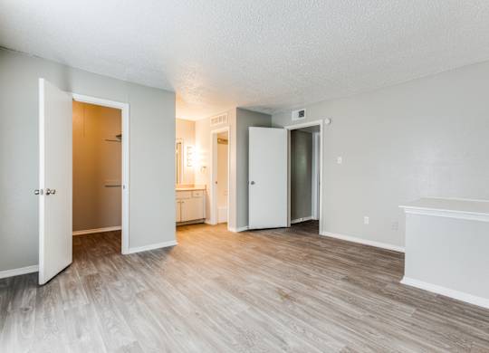 an empty living room with wood flooring and white walls at Falls on Clearwood Apartments, Richardson, TX, Texas